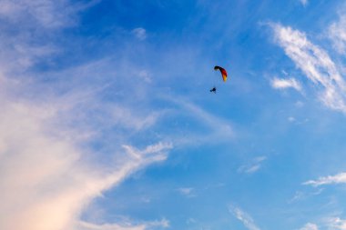 Beyaz bulutlu mavi gökyüzü. Rogalo gökyüzünde uçar.