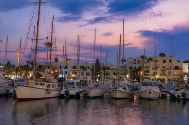 Günbatımında limanda yelkenli. Renkli gökyüzünün arka planına karşı.