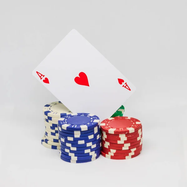 Casino chips, ace of hearts card and plaque with dealer inscription.