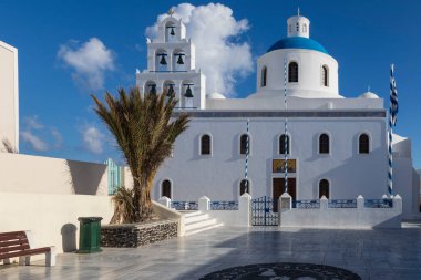 Yunanistan 'ın Santorini adasındaki Oia kasabası. Arka plan koyu bulutlu mavi bir gökyüzü. Beyaz evlerin manzarası