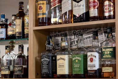 Brno, Çek Cumhuriyeti, Haziran 2020 - Çek Cumhuriyeti 'nde bir restoranda orijinal alkol viski, rom ve burbon şişelerinin bulunduğu ahşap raflar.