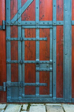 Demir işçiliğiyle süslenmiş güzel, büyük ahşap bir kapı..