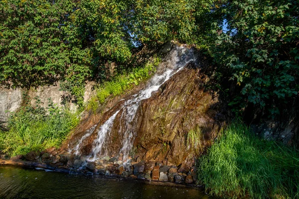 小瀑布的细部从岩石流进池塘 — 图库照片