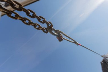 Metal bir klips çelik halatı birbirine bağlar. Arka planda mavi gökyüzü var