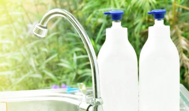 Yeni normal, paslanmaz çelik lavabonun üzerine yeni el sabunu ve alkol jeli şişeleri koy. Tayland 'da okulda el yıkama ve temizleme için. Mikropları ve koronavirüsü önlemek ve korumak için..