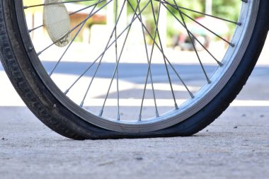 Kaldırımdaki patlak bisiklet lastiğinin yakın görüntüsü.