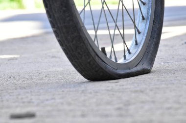 Kaldırımdaki patlak bisiklet lastiğinin yakın görüntüsü.