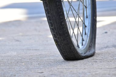 Kaldırımdaki patlak bisiklet lastiğinin yakın görüntüsü.
