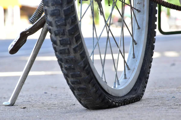 Closeup view of bicycle flat tire on pavement.