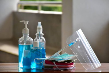 Coronavirus veya Covid-19 'u ve mikropları korumak ve önlemek için içeri girmeden önce el temizleme ve yüz maskesi takmak için ofisin önünde yeni normal el temizleme jeli, yüz temizleme jeli ve yüz maskesi..