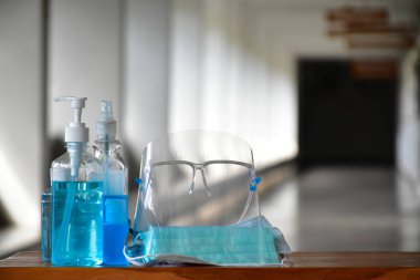 Coronavirus veya Covid-19 'u ve mikropları korumak ve önlemek için içeri girmeden önce el temizleme ve yüz maskesi takmak için ofisin önünde yeni normal el temizleme jeli, yüz temizleme jeli ve yüz maskesi..
