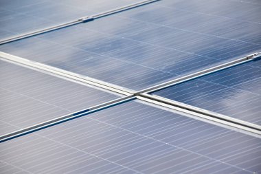 Binaların çatısındaki güneş panelleri ya da fotovotaik sistem. Çevreyi ve yeşil enerjiyi doğadan kurtarma kavramı.