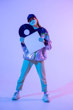 Plastik plaklı kız. Renkli arka plan ve neon ışık. Modern kıyafetler. Müzik posteri. Retro kavramı.