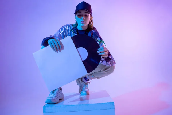 Plastik plaklı kız. Renkli arka plan ve neon ışık. Modern kıyafetler. Müzik posteri. Retro kavramı.