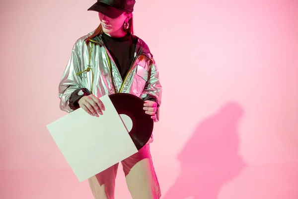 A lány a bakelitlemezzel. Színes háttér és neon fény. Modern ruhák. Zenés poszter. Retro-koncepció. — Stock Fotó