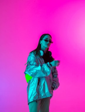 Stüdyoda renkli neon bir arka planda dans eden zarif genç bir kız. Müzik poster tasarımı.