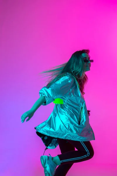 Joven chica elegante bailando en el estudio sobre un fondo de neón de color. Diseño de póster musical . — Foto de Stock