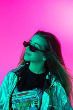 Stüdyoda renkli neon bir arka planda dans eden zarif genç bir kız. Müzik poster tasarımı.