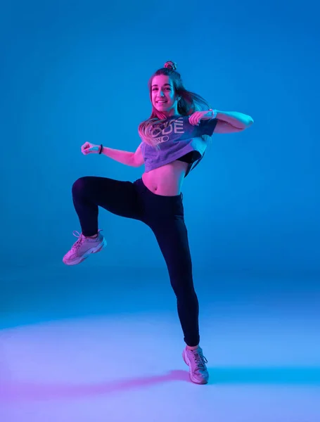 Νεαρό κομψό κορίτσι που χορεύει ζούμπα στο στούντιο σε έγχρωμο φόντο νέον. Σχεδιασμός αφίσας χορού. — Φωτογραφία Αρχείου