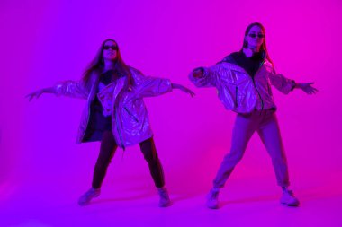 Stüdyoda renkli neon arka planda dans eden zarif kızlar. Müzik dj poster tasarımı.