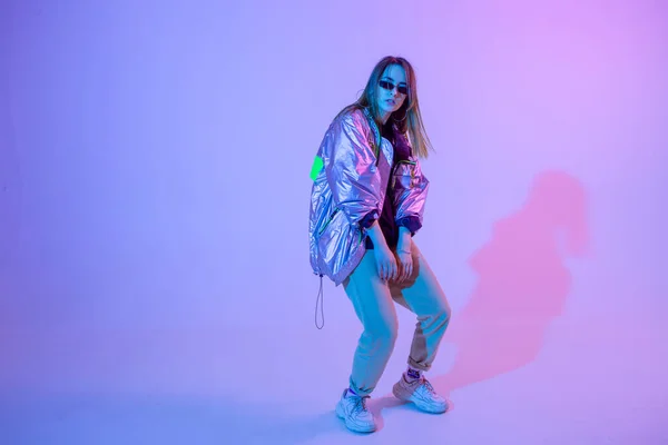 Jong stijlvol meisje dansend in de Studio op een gekleurde neon achtergrond. Muziek dj poster ontwerp. — Stockfoto