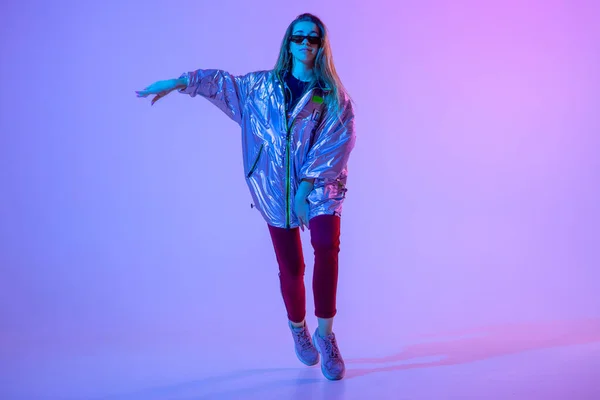 Fiatal elegáns lány táncol a stúdióban egy színes neon háttér. Zene dj poszter design. — Stock Fotó