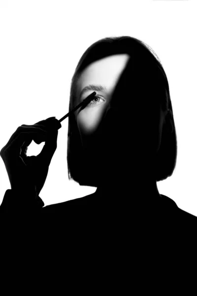 Epico ritratto promozionale di una ragazza con applicatore e pennello mascara. Concetto di pubblicità minimalista in bianco e nero . — Foto Stock