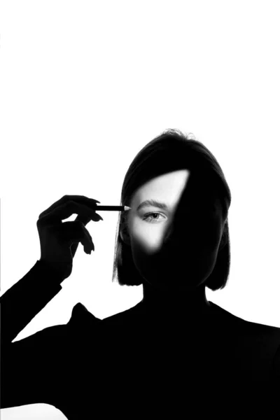 Ritratto di ragazza su sfondo bianco. Il modello di moda usa la matita cosmetica per sopraccigli e palpebre. Bianco-nero . — Foto Stock