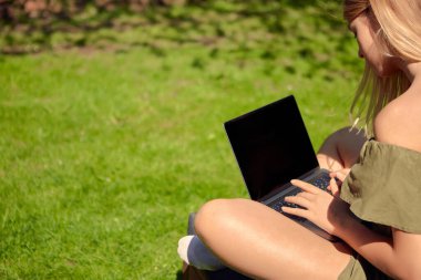 Yaratıcı bir genç kız blogcu bahçedeki bir evin arka bahçesinde oturmuş içerik üzerine çalışıyor..