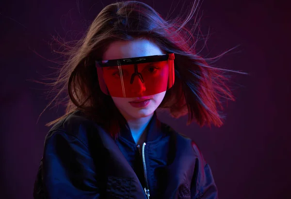 Portrét stylové DJ dívka, brýle a bunda v nočním klubu na tmavém pozadí v neonovém světle — Stock fotografie