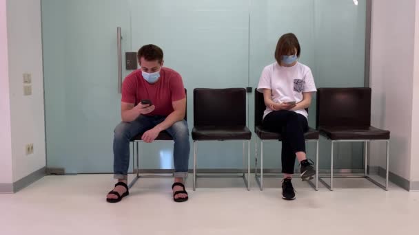Sağlık maskeli gençler, sıraya girip hastanede doktor randevusu bekliyorlar.. — Stok video