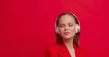 Kablosuz kulaklıklı güzel bir genç kız neşeli bir şekilde şarkı dinler. parlak renkli müzik afişi.