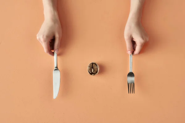 Snack sain de noix et les mains avec fourchette et couteau isolé sur fond beige, photographie conceptuelle pour blog alimentaire — Photo