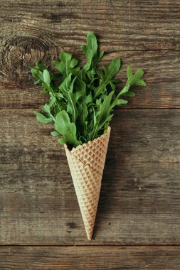 Tahta masada yeşil roka salatası, sağlıklı atıştırmalık, konsept fotoğrafçılık ve yemek blogu içeriği.