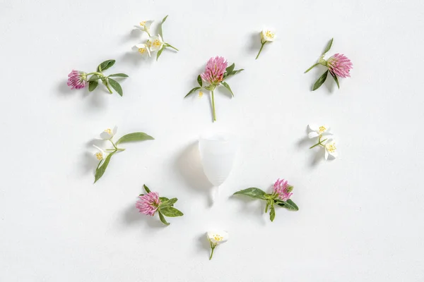 Coupe menstruelle écologique réutilisable et silicone et fleurs en forme de coeur isolé sur un fond blanc — Photo