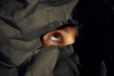 Kadınların gözü siyah buruşuk kağıt arkaplanda, blog veya poster için minimalist konsept fotoğrafçılığı