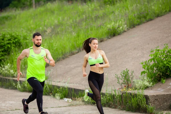 Спортсменка і чоловік в стильному спортивному одязі бігають на природі, фото для блогу і реклами спорту і здорового способу життя — стокове фото