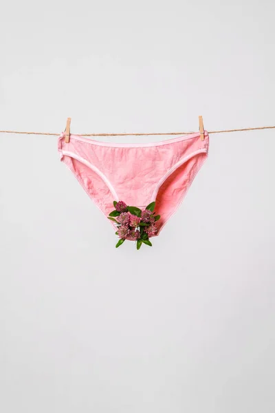 Frauenunterwäsche in rosa mit Blumen an der Wäscheleine, Konzeptinhalte für feministischen Blog, Poster über Frauengesundheit — Stockfoto