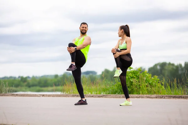 Спортсмен і дівчинка роблять пілатес разом на вулиці. Здоровий спортивний спосіб життя. Фотографія для реклами або блогу — стокове фото