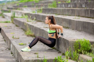 Atletik genç kız şehirde merdivenlerden şınav, sağlıklı bir yaşam tarzı için fotoğraf ya da spor blogu