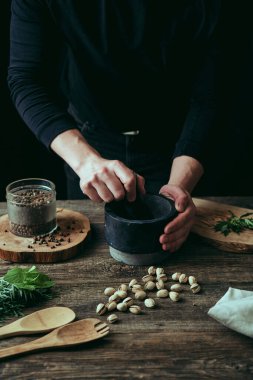 Mutfakta yemek hazırlayan ellerin yakın çekimi. Ev mutfağının kapkara arka planı. Sağlıklı beslenme kavramı.