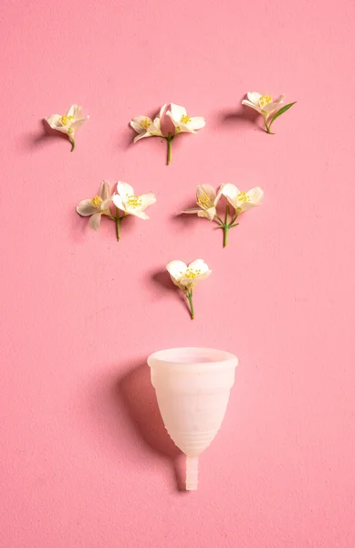 Coupe menstruelle écologique réutilisable et silicone et fleurs isolées sur un fond rose — Photo