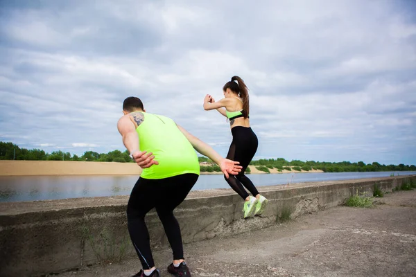 Спортивний хлопець і дівчина фітнес тренери тренуються і стрибають на вулиці. Здоровий спортивний спосіб життя. Фотографія для реклами або блогу — стокове фото