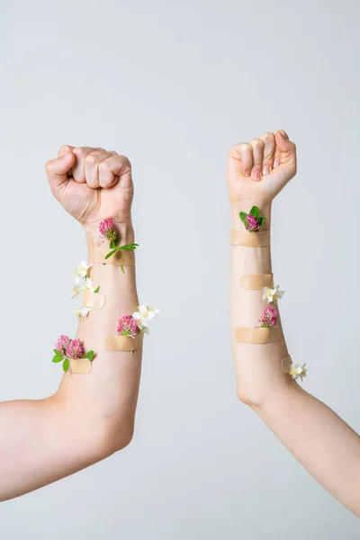 Les hommes et les femmes poing élevé comme symbole du féminisme avec des taches médicales et des fleurs. Concept poster pour blog féministe — Photo