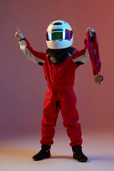 Menino legal criança piloto no capacete com medalhas, de pé em luz de néon. Cartaz da escola de corridas de kart. Anúncio — Fotografia de Stock