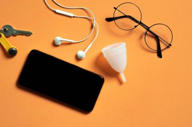 Büyük boş ekranlı modern telefon ve regl kupası eko dostu ve silikon, kadın uygulaması veya blog için fotoğraf