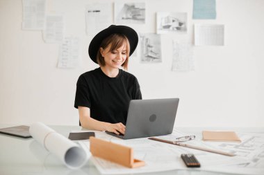 Genç yaratıcı kız tasarımcı ofiste iç mimarlık projesi geliştiriyor. Reklam eğitimleri veya tasarım hizmetleri için fotoğraf
