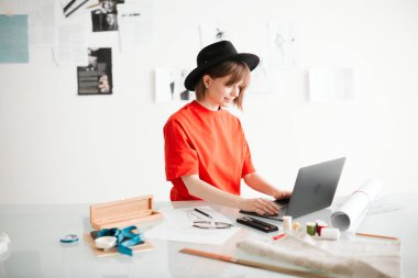 Stüdyoda çalışan genç bir moda tasarımcısı. Blog ya da reklam eğitim kursları ya da kıyafetler için fotoğrafçılık
