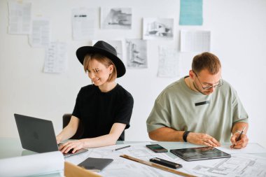 Genç yaratıcı tasarımcılar kız ve erkek ofiste proje geliştiriyorlar. Reklam eğitimleri veya tasarım hizmetleri için fotoğraf