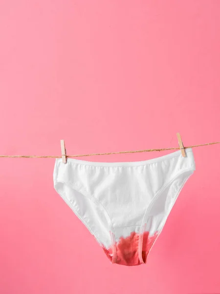 Damenunterwäsche auf Wäscheleine isoliert auf rosa Hintergrund, Konzeptposter über Frauengesundheit und Menstruation — Stockfoto